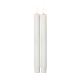 Két darab 25 cm magas, fehér LED vacsoragyertya valódi viaszból, kannelúrás felülettel, meleg fényű pislákoló lánggal, fehér háttérrel.